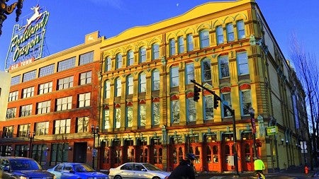 Photo of UO Portland's building beneath the famous "White Stag" billboard