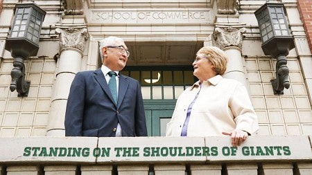 Steven Matsunaga and Robin Clement stand outside the entrance to Anstett Hall