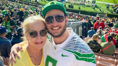 Jamie Carr (left) and son Tyler (right) embrace in the stands at the Rose Bowl