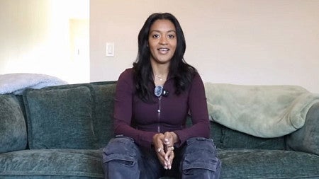 Screenshot of a video with Jaya Sawhney sitting on a couch