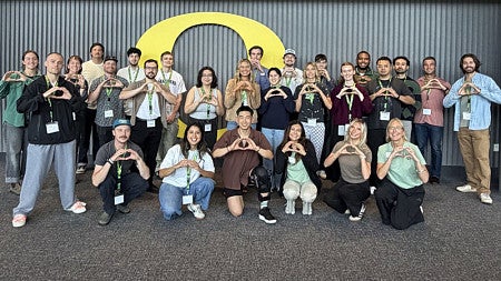 The incoming SPM class of 2028 poses for a group photo while making the -O- symbol with their hands