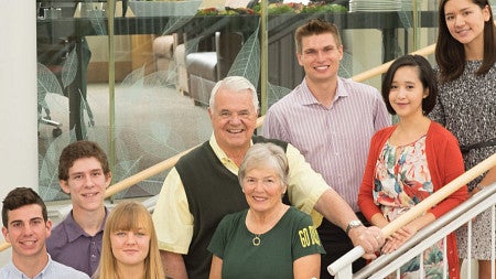 Gerry and Marilyn Cameron and others pose for a photo on a staircase in the Lillis atrium