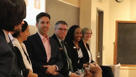 Panelists smile and laugh during a panel discussion
