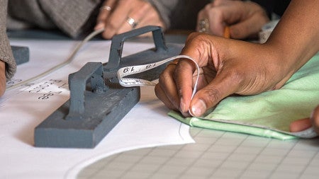 Close up photo of students working on measuring a sports product
