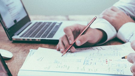 Close up photo of a person working at a laptop