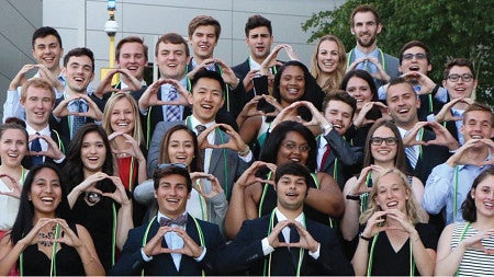 A group of business honors students make the Oregon "O" sign