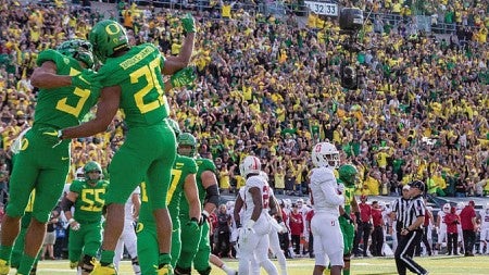 Two football players on the field at Autzen Stadium
