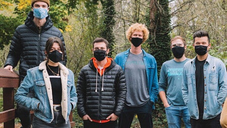 A group photo of the Studio Skosh team alongside a photo of their wireless charger design