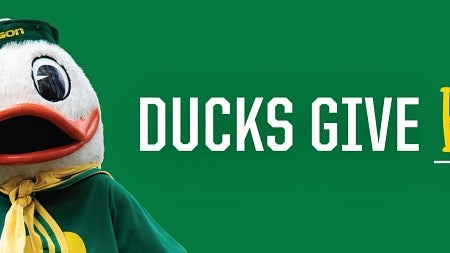 Photo of the UO Duck next to the words "Ducks Give Back"