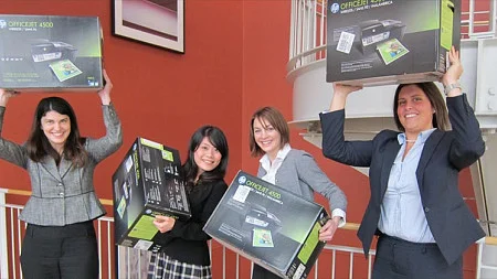 Students hold up the printers they won from the competition