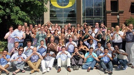 Group photo of Nyenrode students throwing the Oregon "O" in front of the Lillis Business Complex