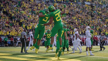 Two football players collide mid-jump