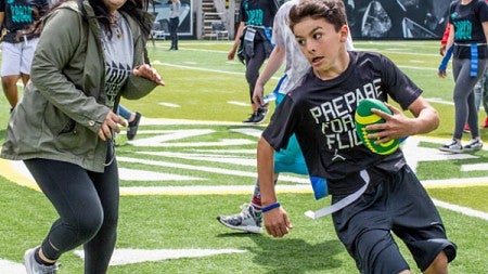 Children play field games on Autzen Stadium