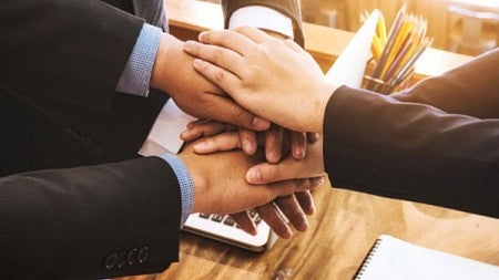 Business workers joining hands