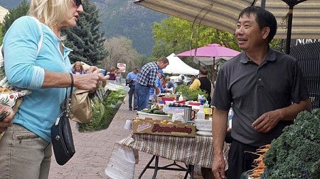 People look at vegetables at a farmer's market