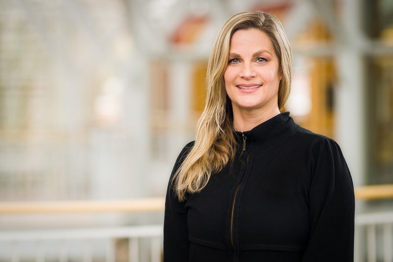 Kate Werdebaugh. White woman with blonde, long hair in black blouse, smiling.