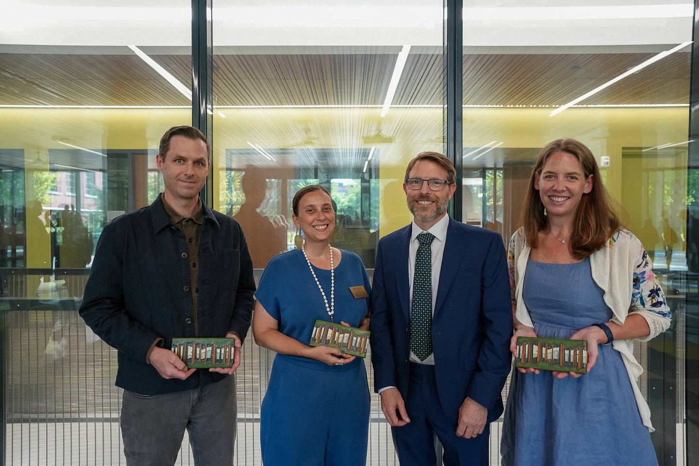 three faculty award winners pose with dean of college of arts and sciences