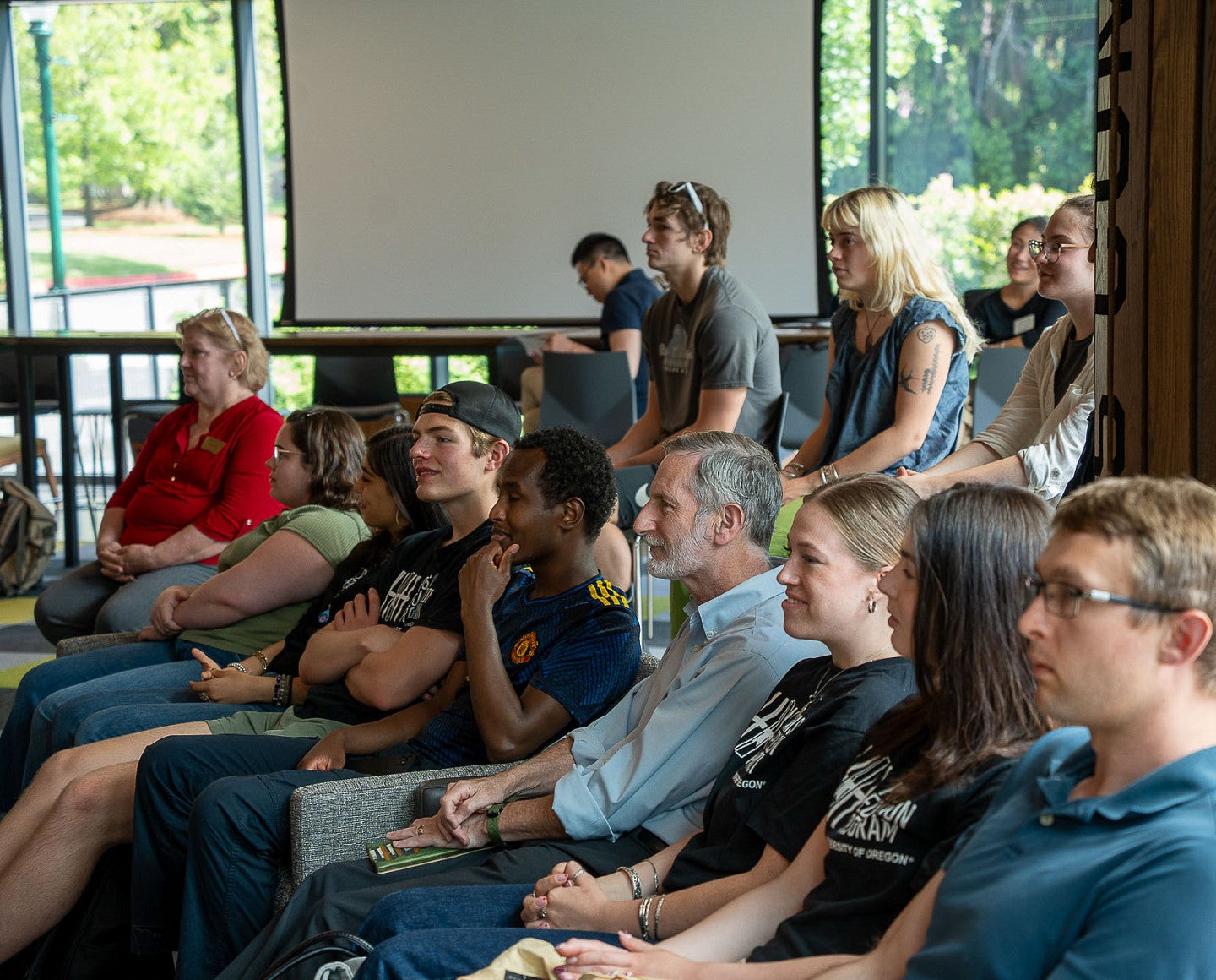 a group of people indoors watching a presentation