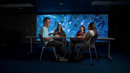 Four students sit in the humanities lab. 