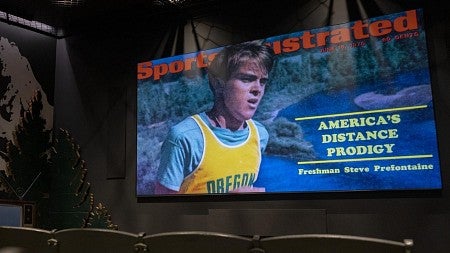 a cover of sports illustrated on a TV screen with seats in front of it