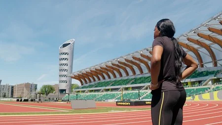 a woman stands in Hayward Field