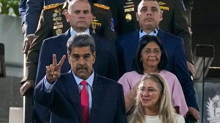 Maduro of Venezuela wearing a suit flashes the peace sign