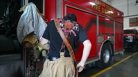a firefighter works on a firetruck