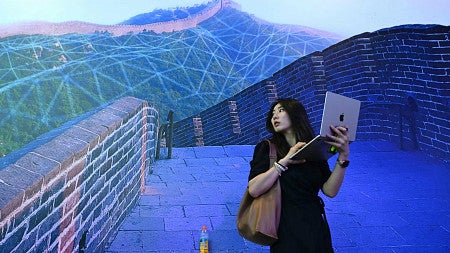 an illustration of a chinese woman on a laptop on the great wall of china