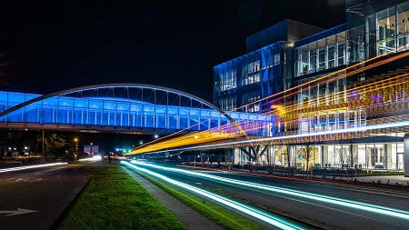 the knight campus skybridge lit at night
