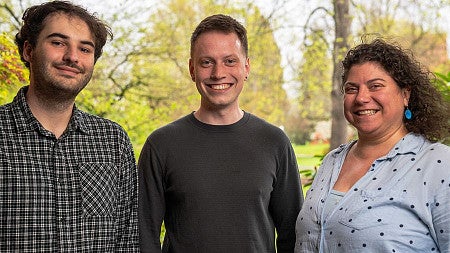 three people pose in a photo
