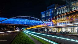the knight campus skybridge lit at night