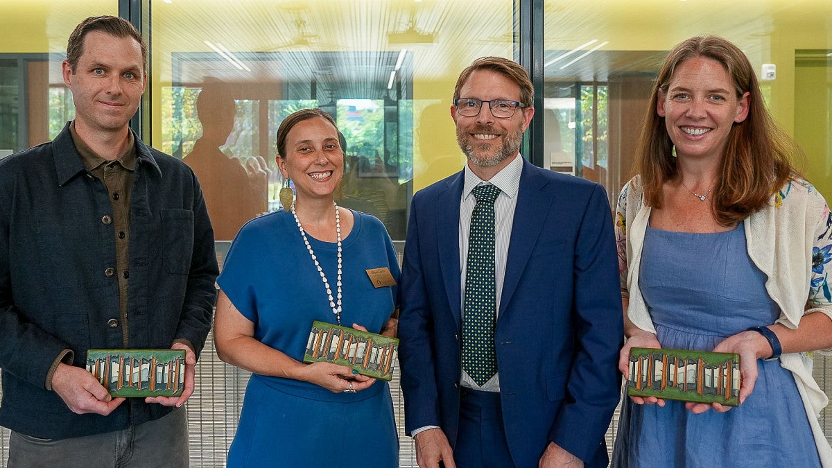 people stand together holding award that are decorative tiles