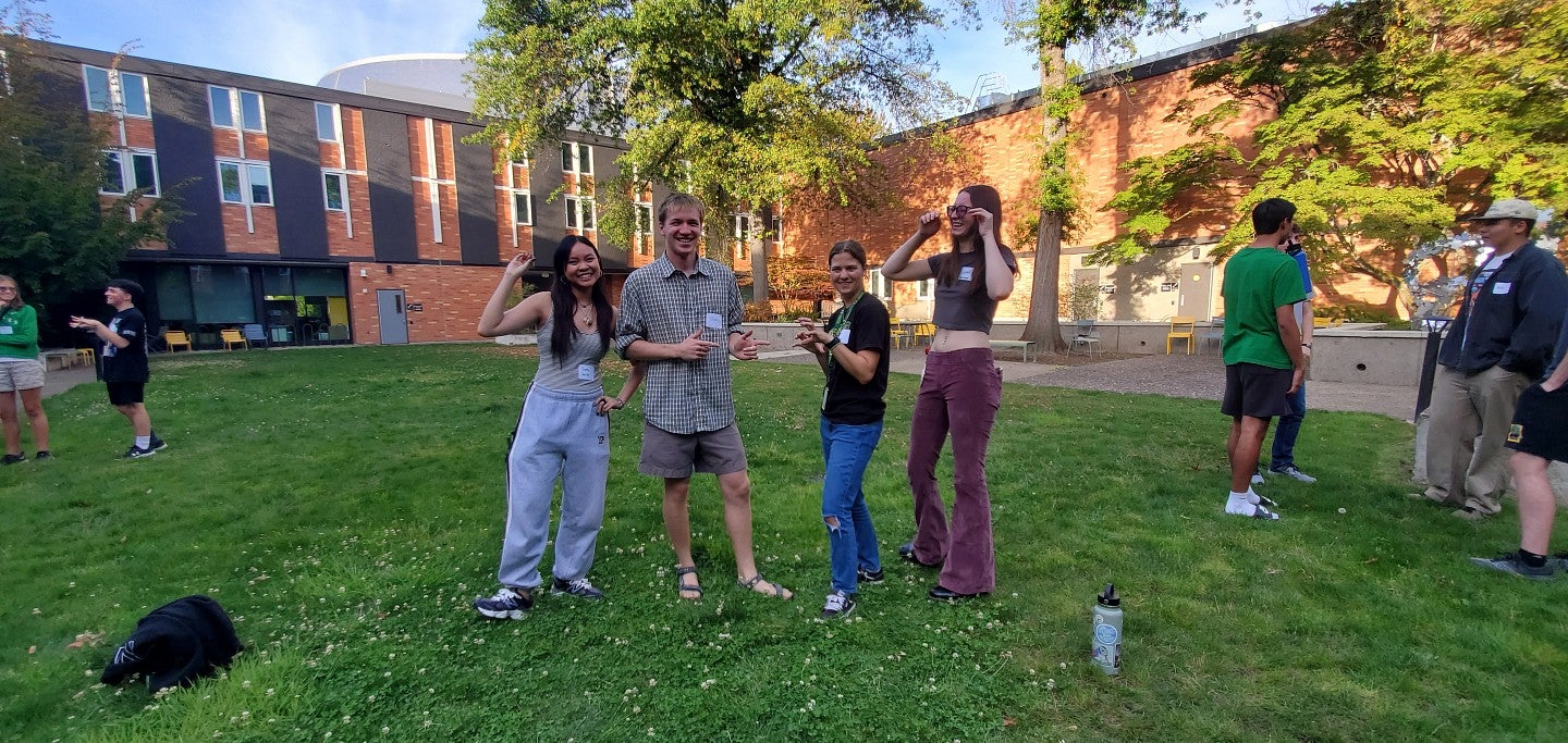 Four students laughing in the Justice Bean Hall courtyard.