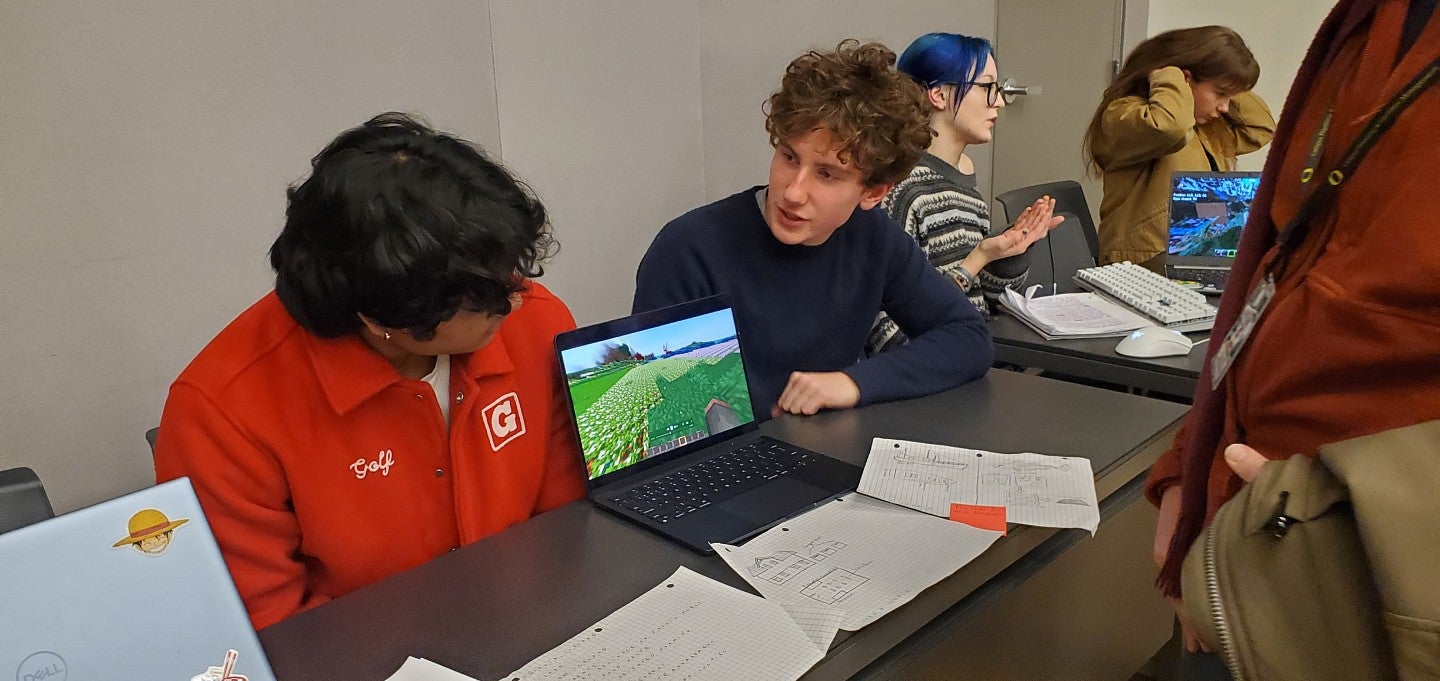 Two students showcase their final project at a class symposium