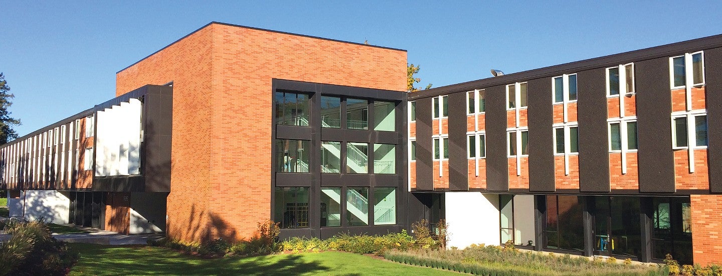 Photograph of Justice Bean Hall, a primarily red brick building with tall windows.