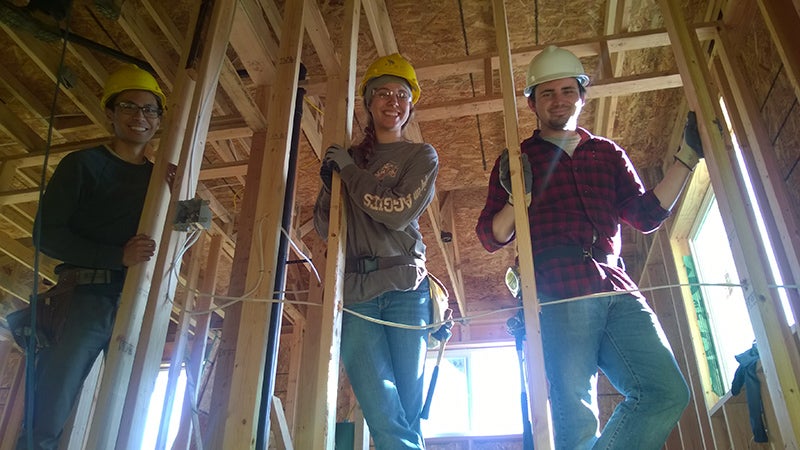 Erick Bernabe, Chelsea Koh, and Logan Goins work on framing.