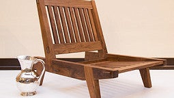 A wooden chair with silver pitcher