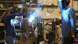 Metal sculptor Jud Turner, BA fine arts, ’95, mentors middle school student Taja Kester