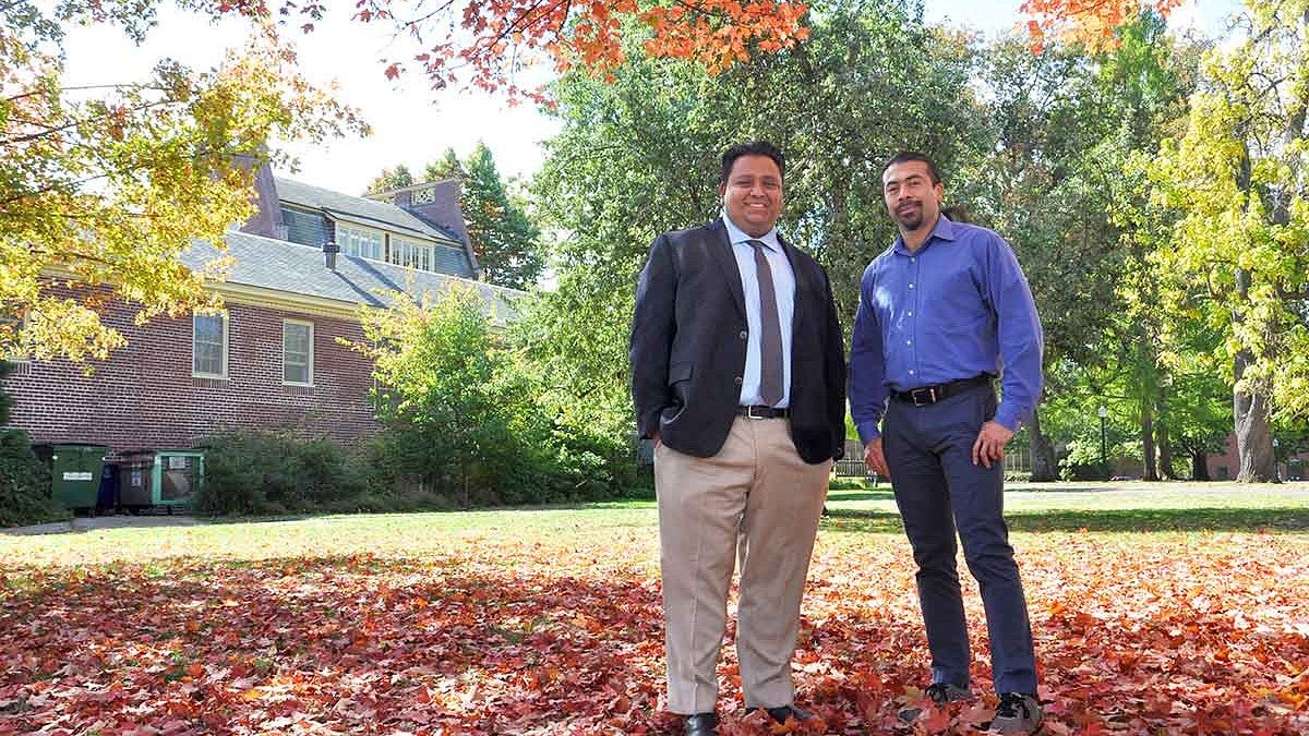 Two men standing under an autumn tree