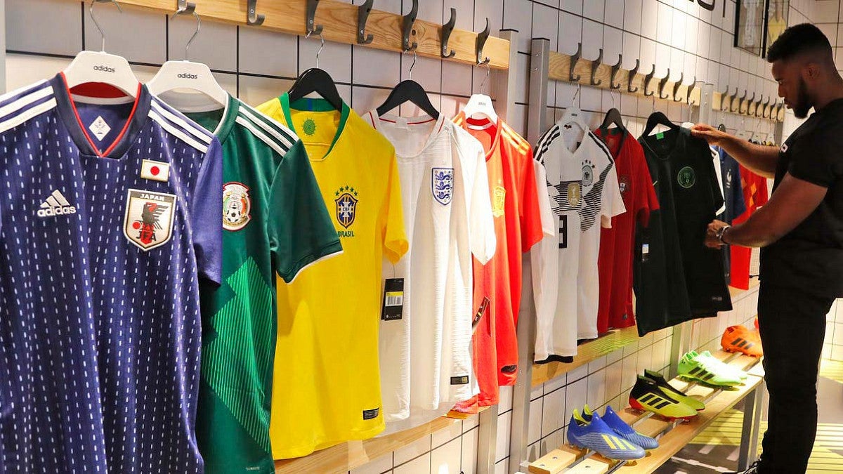 person looks at soccer jerseys on display