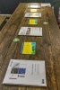 Photograph of materials from the SCYP meeting. Spread out in a line on a wooden desk. 