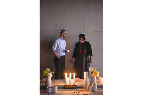 Two people standing at candle lit table