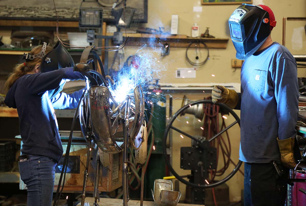 Metal sculptor Jud Turner, BA fine arts, ’95, mentors middle school student Taja Kester