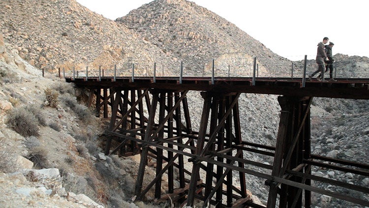 click to enlarge Rueter and Benedict walk on train trestle