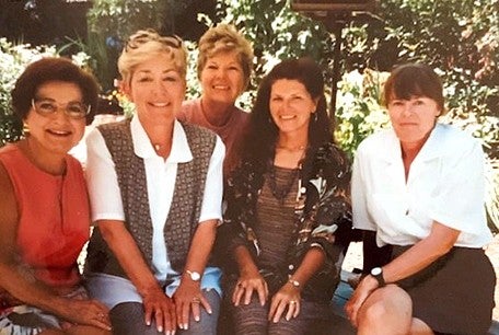 individuals sitting together looking at camera and smiling