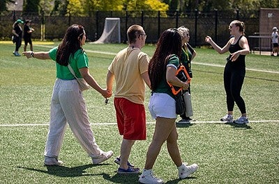 Grecia Acevedo with students on a soccer field