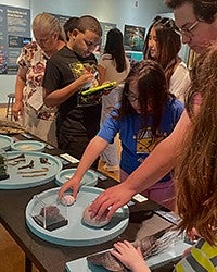 Grecia Acevedo with students at an event table