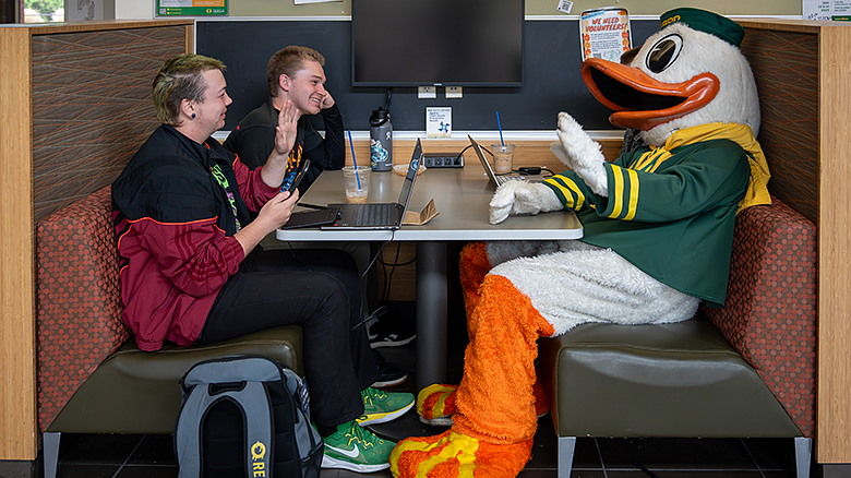 Oregon Duck sitting with students in HEDCO lobby