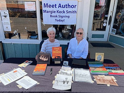 individuals sitting at a table for an author's book signing