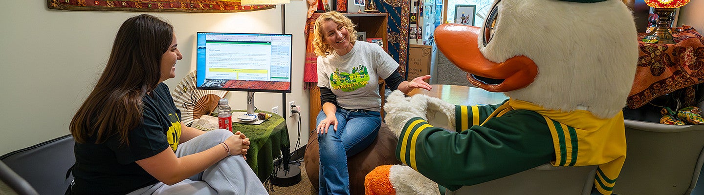 student advisors sitting with a student and the UO Duck mascot